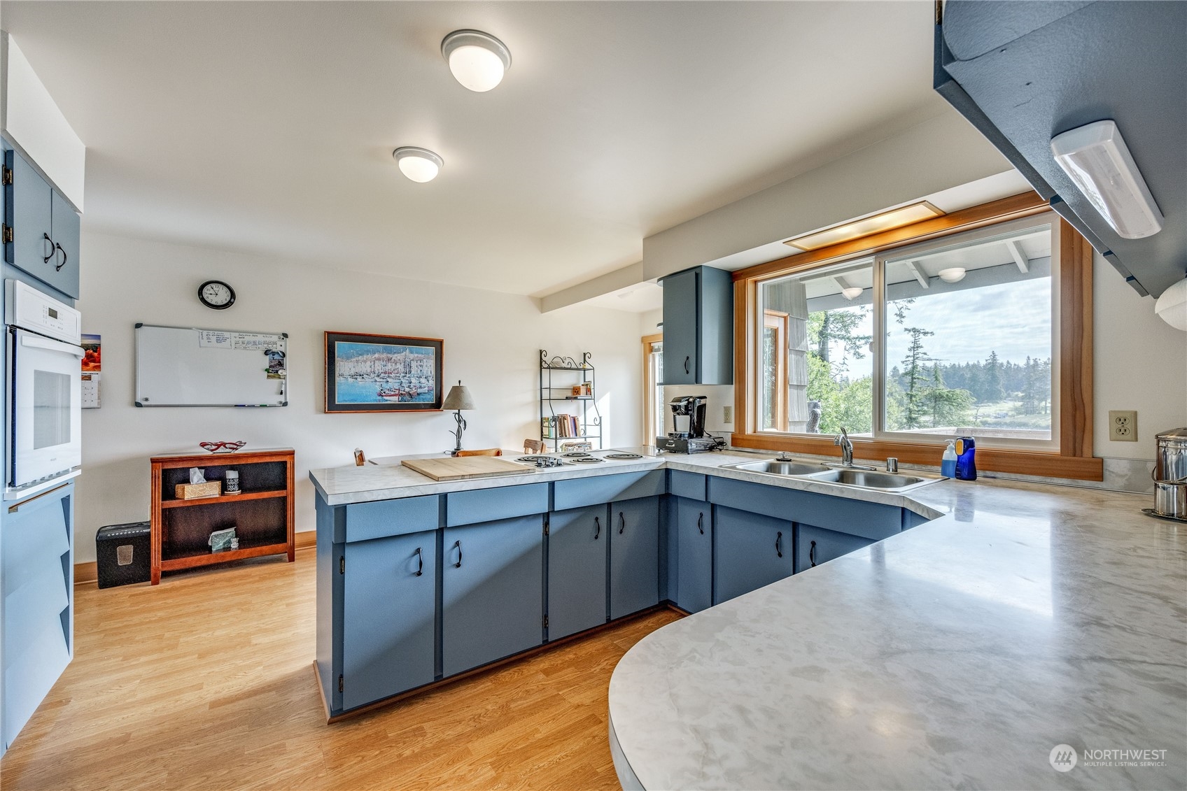 1511 Griffith Point Road Nordland, WA 98358 - Photo 12 of 40 a large kitchen with stainless steel appliances a stove a refrigerator a sink dishwasher and wooden cabinets with wooden floor