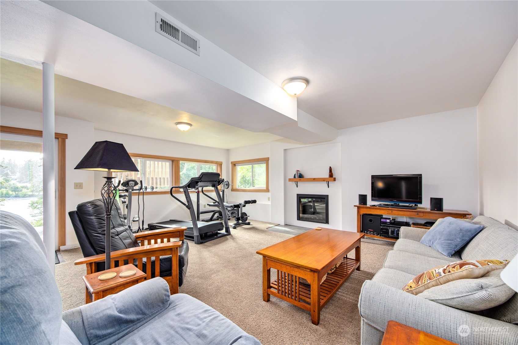1511 Griffith Point Road Nordland, WA 98358 - Photo 26 of 40 a living room with furniture a fireplace and a flat screen tv