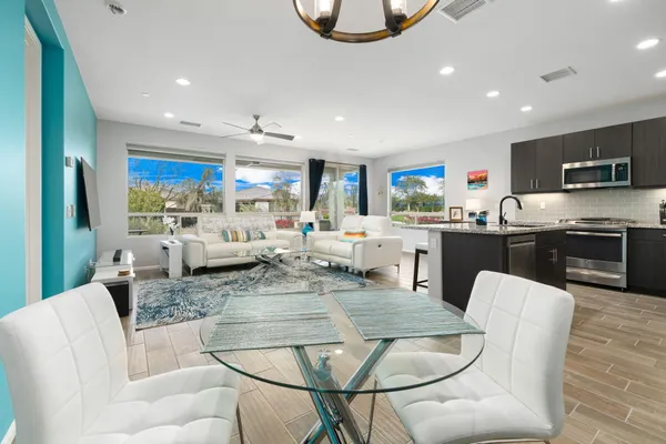 a living room with stainless steel appliances kitchen island granite countertop furniture a couch and a view of kitchen