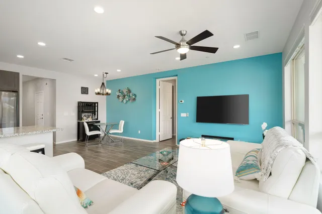 a living room with furniture a flat screen tv and a large window