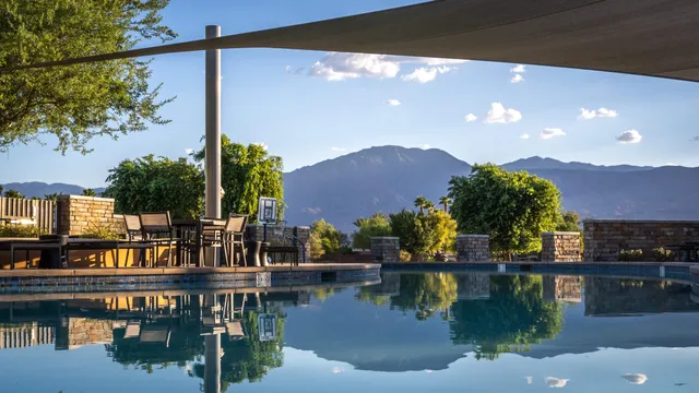 a view of a chairs and table in patio with a lake view
