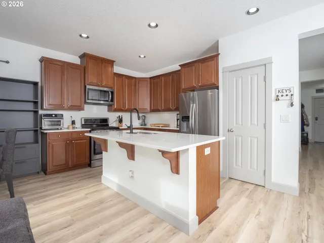 a kitchen with stainless steel appliances granite countertop a stove microwave and cabinets