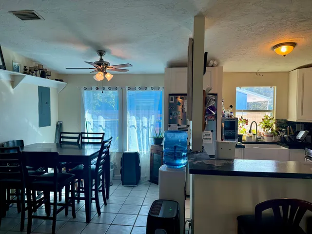 a view of a dining room and kitchen with furniture and a chandelier