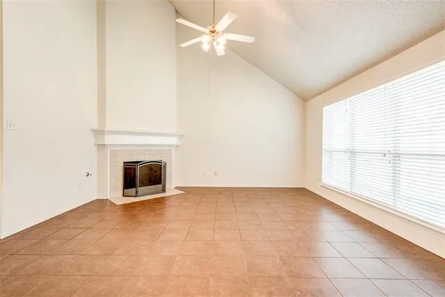 an empty room with windows and fireplace