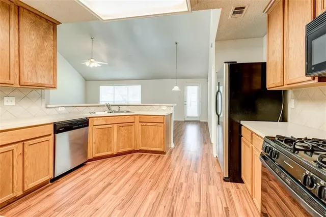 a kitchen with stainless steel appliances a white stove top oven and sink