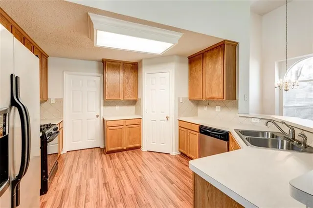 a kitchen with a wooden floor and a refrigerator