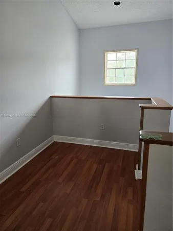 a view of a room with wooden floor and window
