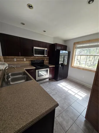 a living room with stainless steel appliances a stove a microwave and a counter top space