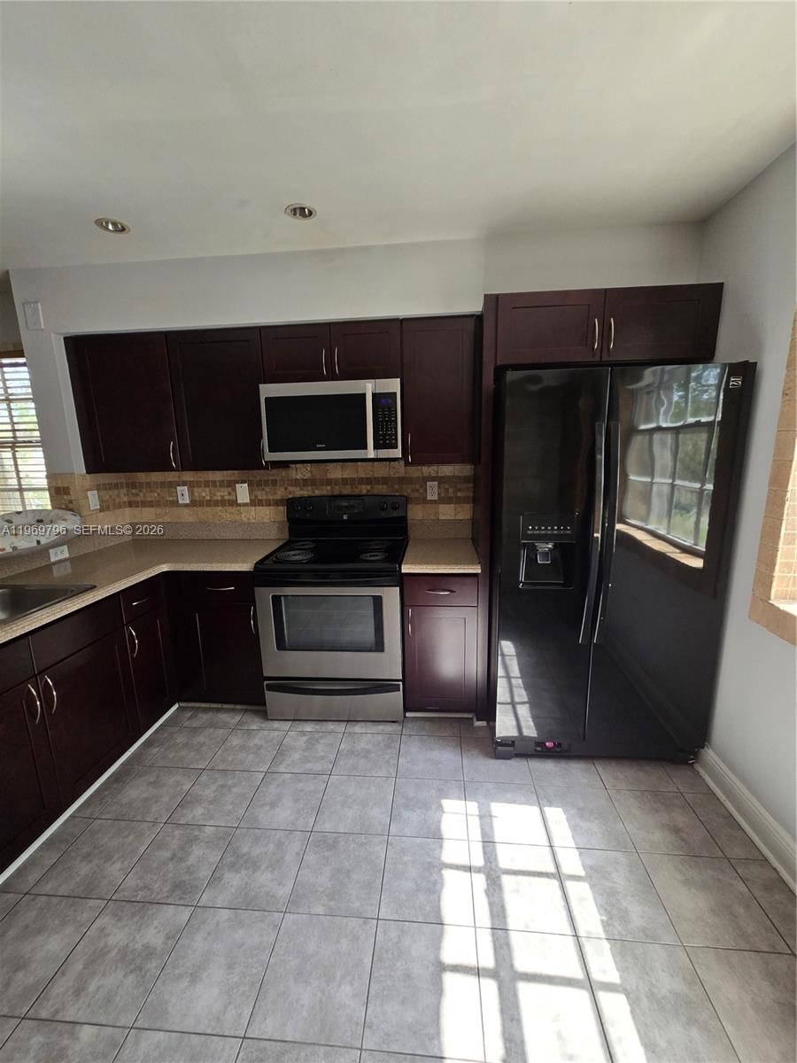 14611 Balgowan Road, Unit 2041 Miami Lakes, FL 33016 - Photo 7 of 22 a kitchen with stainless steel appliances granite countertop a refrigerator and a stove top oven