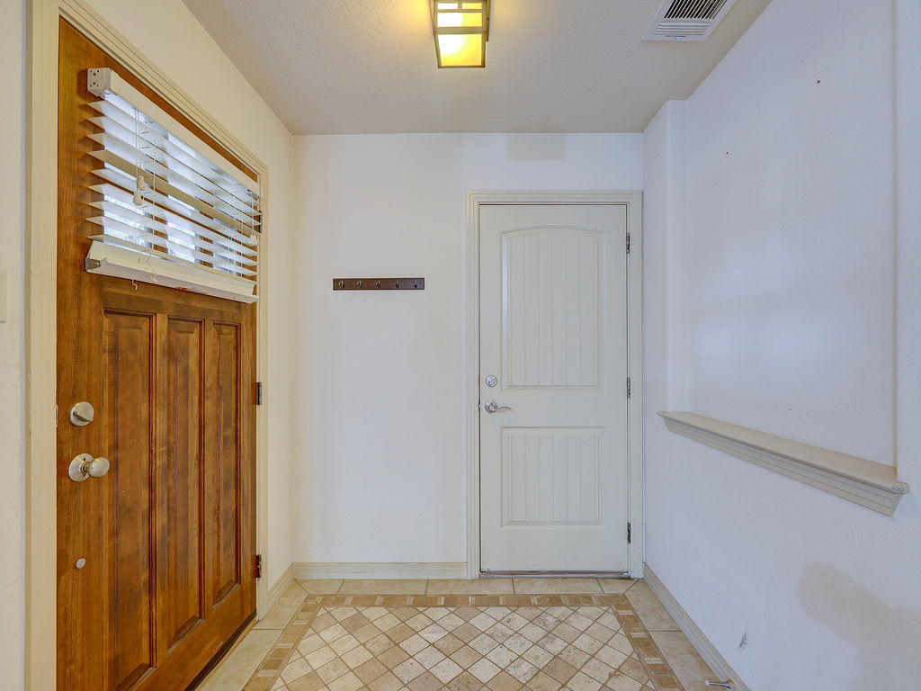 9707 Anderson Mill Road, Unit 22 Austin, TX 78750 - Photo 9 of 39 A welcoming entryway features rich wooden and crisp white panel doors, all anchored by a decorative tiled floor.