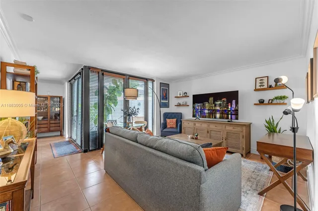 a living room with furniture a flat screen tv and a floor to ceiling window