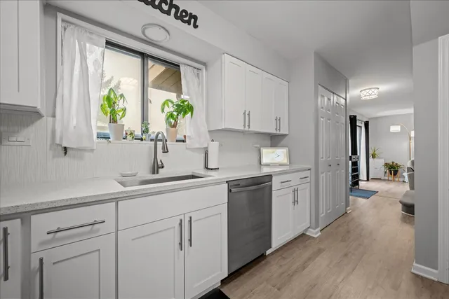 a kitchen with white cabinets and a window