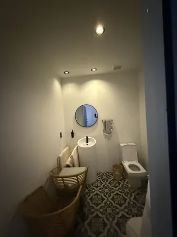 a bathroom with a sink mirror vanity and toilet