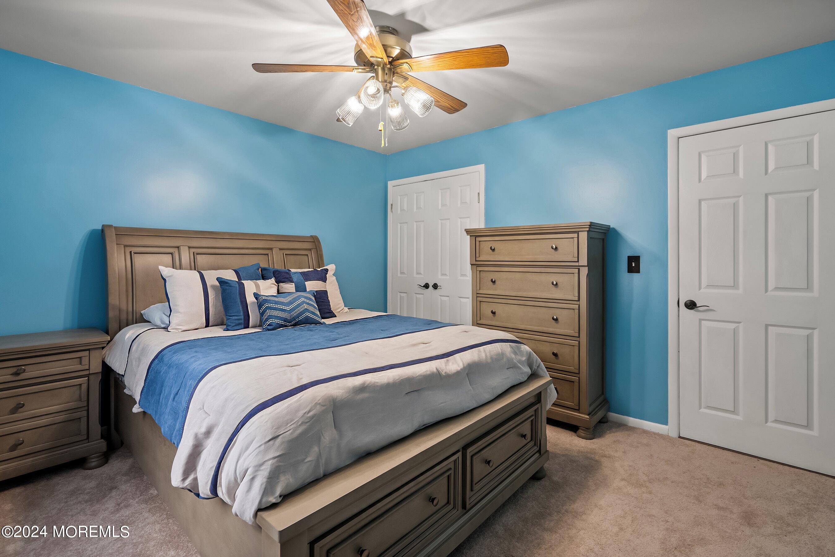 34 Maple Street Waretown, NJ 08758 - Photo 29 of 36 a bed room with a bed and a chandelier