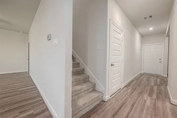 a view of a hallway with wooden floor and entryway