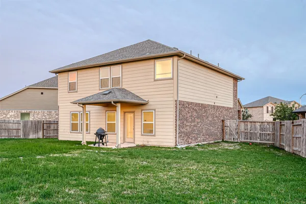 a view of a big house with a big yard and large trees