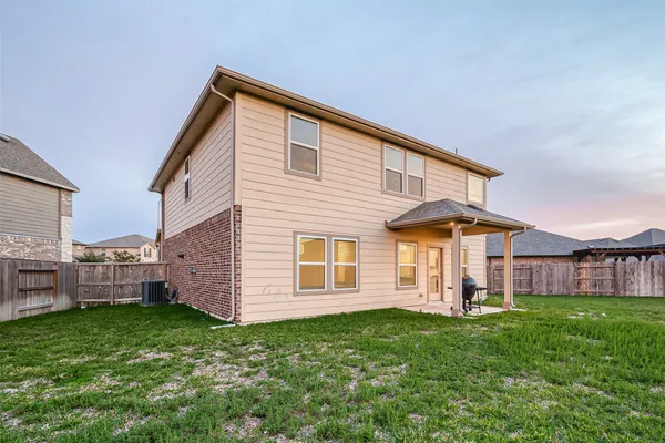 a view of a house with a big yard and large trees