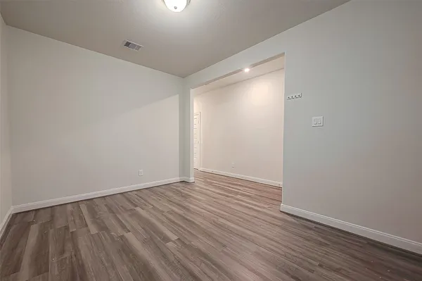 a view of an empty room with wooden floor