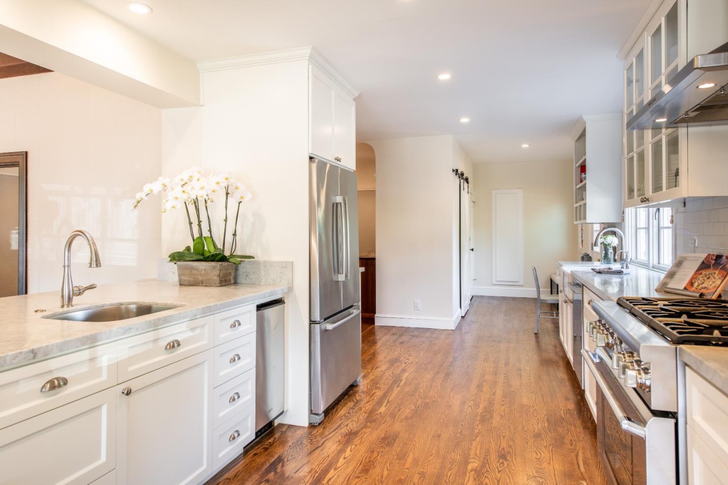 843 Crossway Road Burlingame, CA 94010 - Photo 12 of 36 a kitchen with kitchen island granite countertop a refrigerator a sink dishwasher a stove and white cabinets with wooden floor