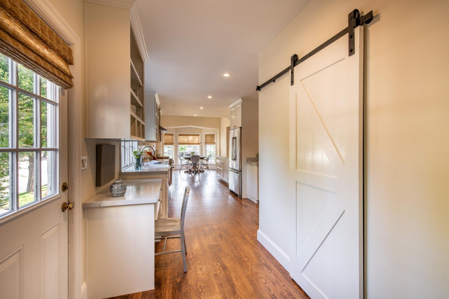 843 Crossway Road Burlingame, CA 94010 - Photo 14 of 36 a kitchen with stainless steel appliances a refrigerator a sink a stove and white cabinets next to a window