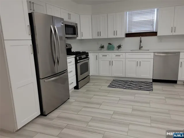 a kitchen with stainless steel appliances a refrigerator sink and microwave