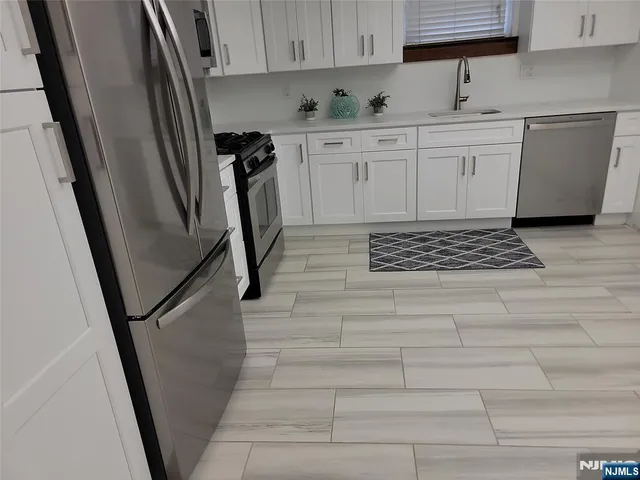 a kitchen with a sink a refrigerator and cabinets