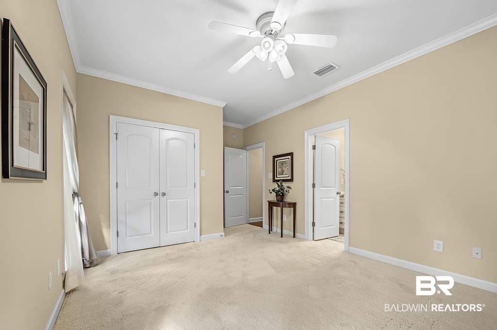 29976 Dolive Ridge Daphne, AL 36527 - Photo 42 of 58 Unfurnished bedroom featuring a closet, ceiling fan, ornamental molding, and light colored carpet