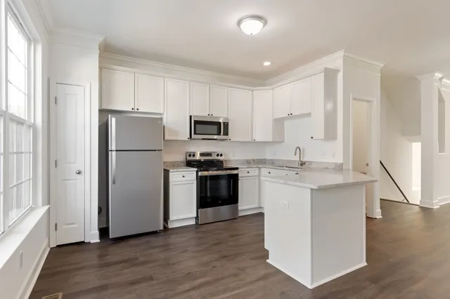 a view of a kitchen with wooden floor and a window
