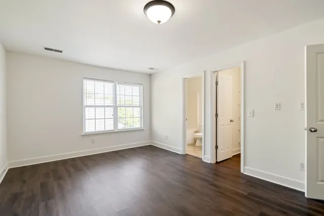 an empty room with wooden floor and a window