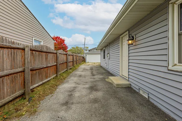a view of a pathway of a house with wooden fence