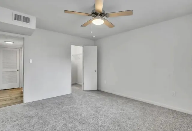en empty room with fan and a ceiling fan