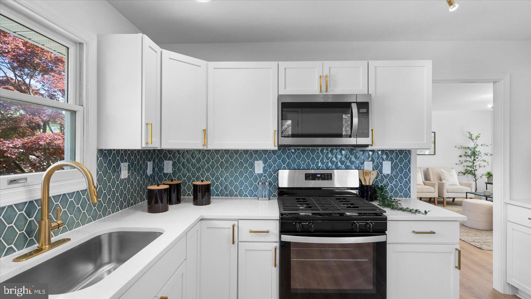 804 Suburbian Road Reisterstown, MD 21136 - Photo 13 of 36 a kitchen with granite countertop a stove a sink and a microwave