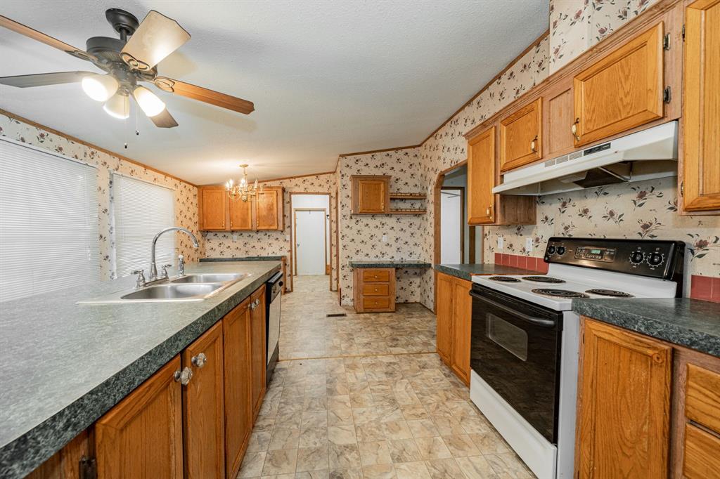 1312 Crowell Road Kaufman, TX 75142 - Photo 17 of 38 a kitchen with stainless steel appliances granite countertop a sink a stove cabinets counter space and stainless steel appliances