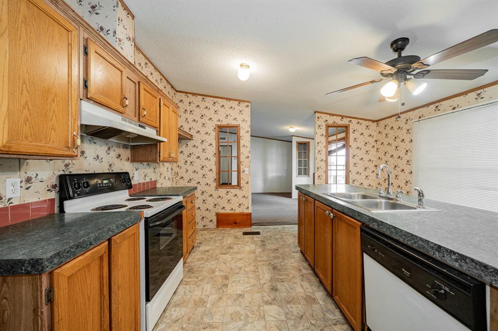 1312 Crowell Road Kaufman, TX 75142 - Photo 20 of 38 a kitchen with stainless steel appliances granite countertop a sink a stove top oven a counter space and cabinets