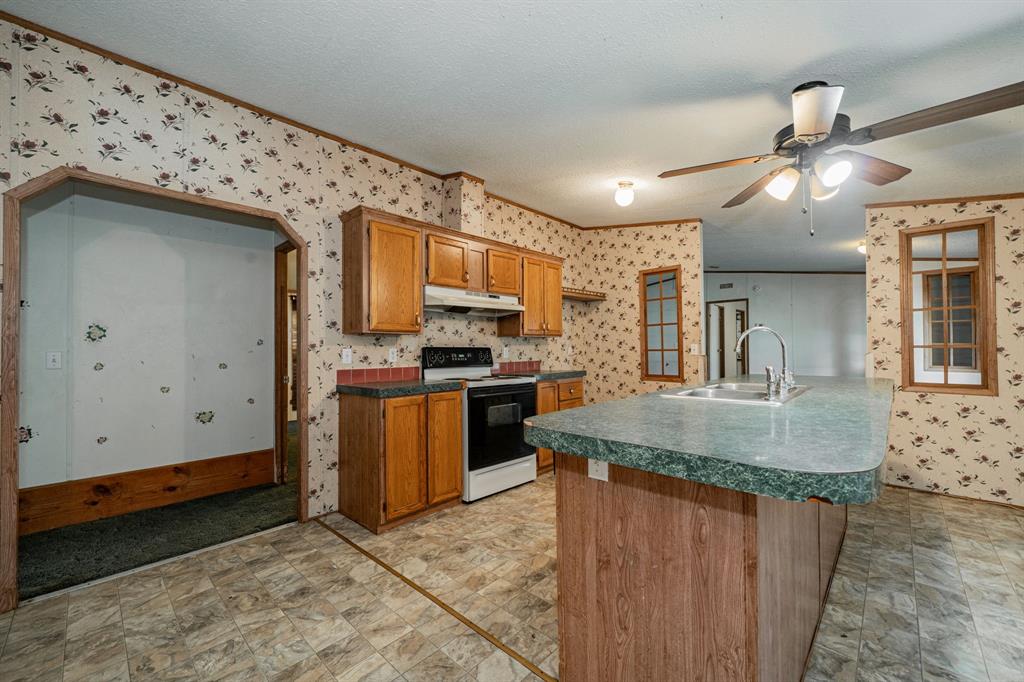 1312 Crowell Road Kaufman, TX 75142 - Photo 22 of 38 a kitchen with stainless steel appliances granite countertop a sink a stove and a refrigerator