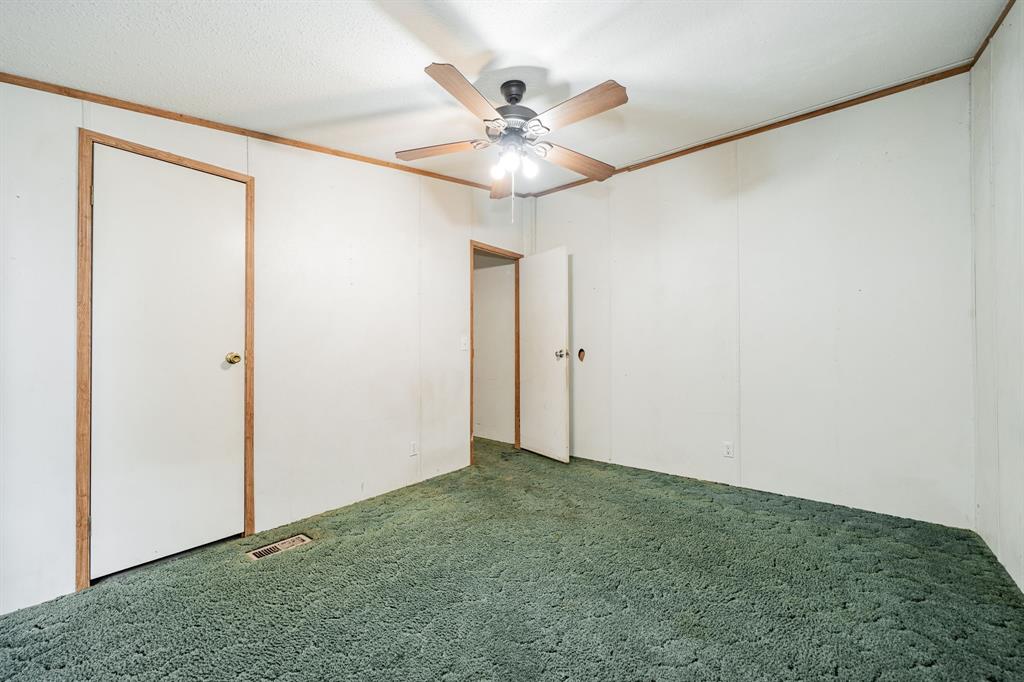 1312 Crowell Road Kaufman, TX 75142 - Photo 27 of 38 an empty room with a ceiling fan and a window