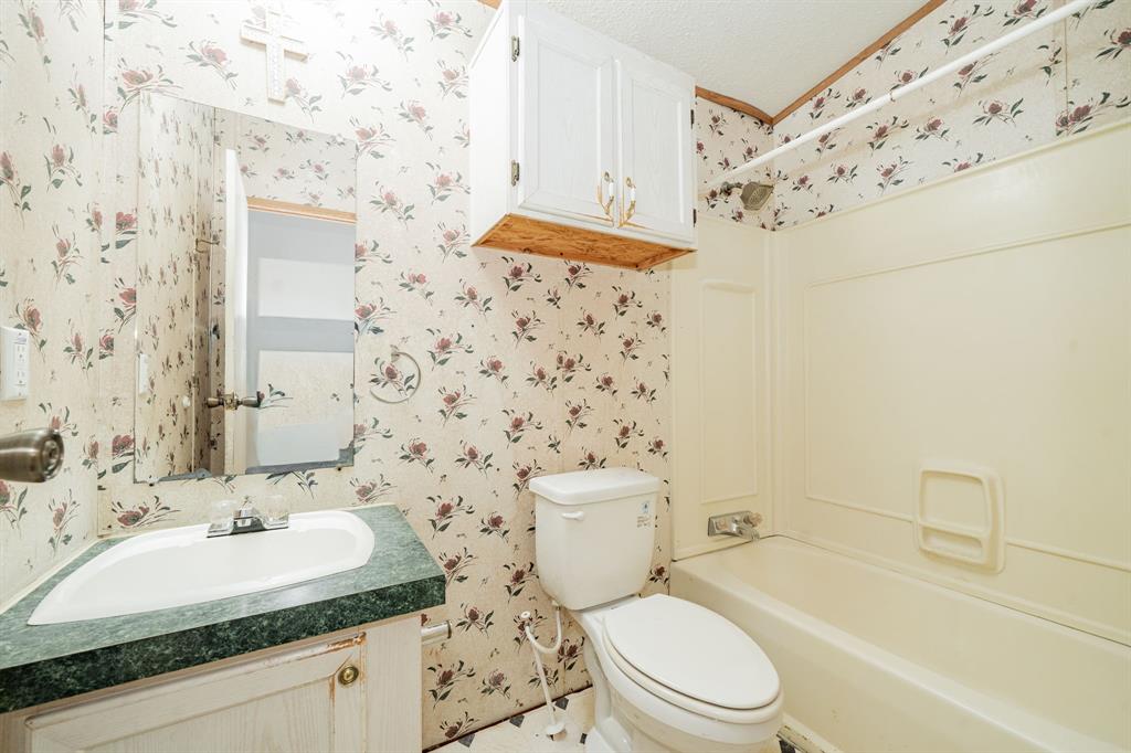 1312 Crowell Road Kaufman, TX 75142 - Photo 28 of 38 a bathroom with a sink a toilet and shower curtain