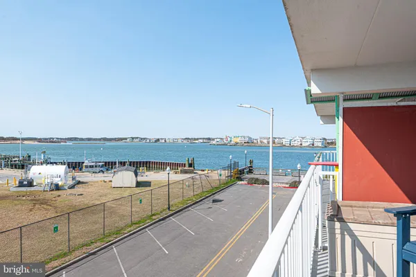 a view of a hallway with wooden floor and a bathroom