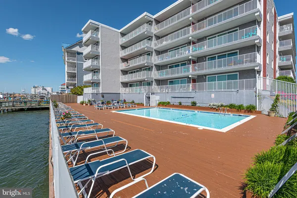a view of a dining room and livingroom with furniture wooden floor a chandelier
