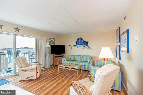 a kitchen with stainless steel appliances granite countertop a refrigerator a sink a stove a dining table and chairs