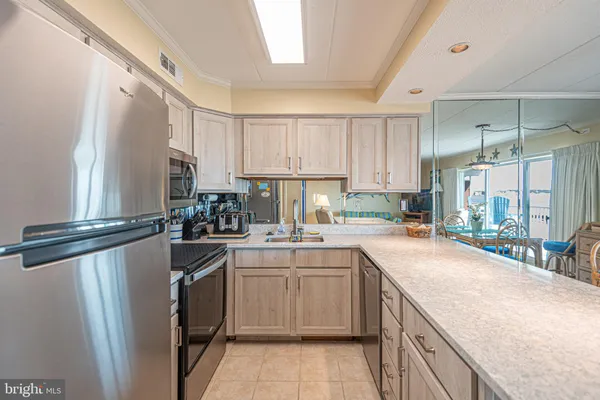 a view of a dining room kitchen and a kitchen island stainless steel appliances