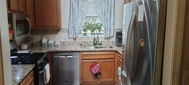 a kitchen with stainless steel appliances granite countertop a refrigerator and a sink