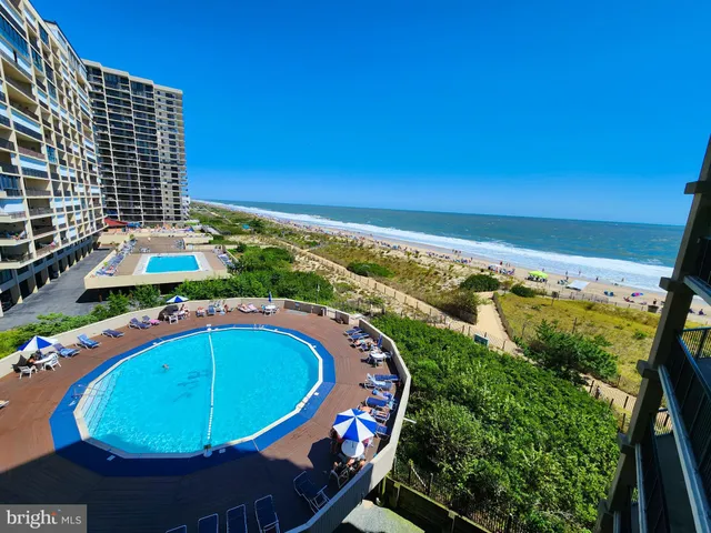 a view of a swimming pool with a yard and outdoor seating