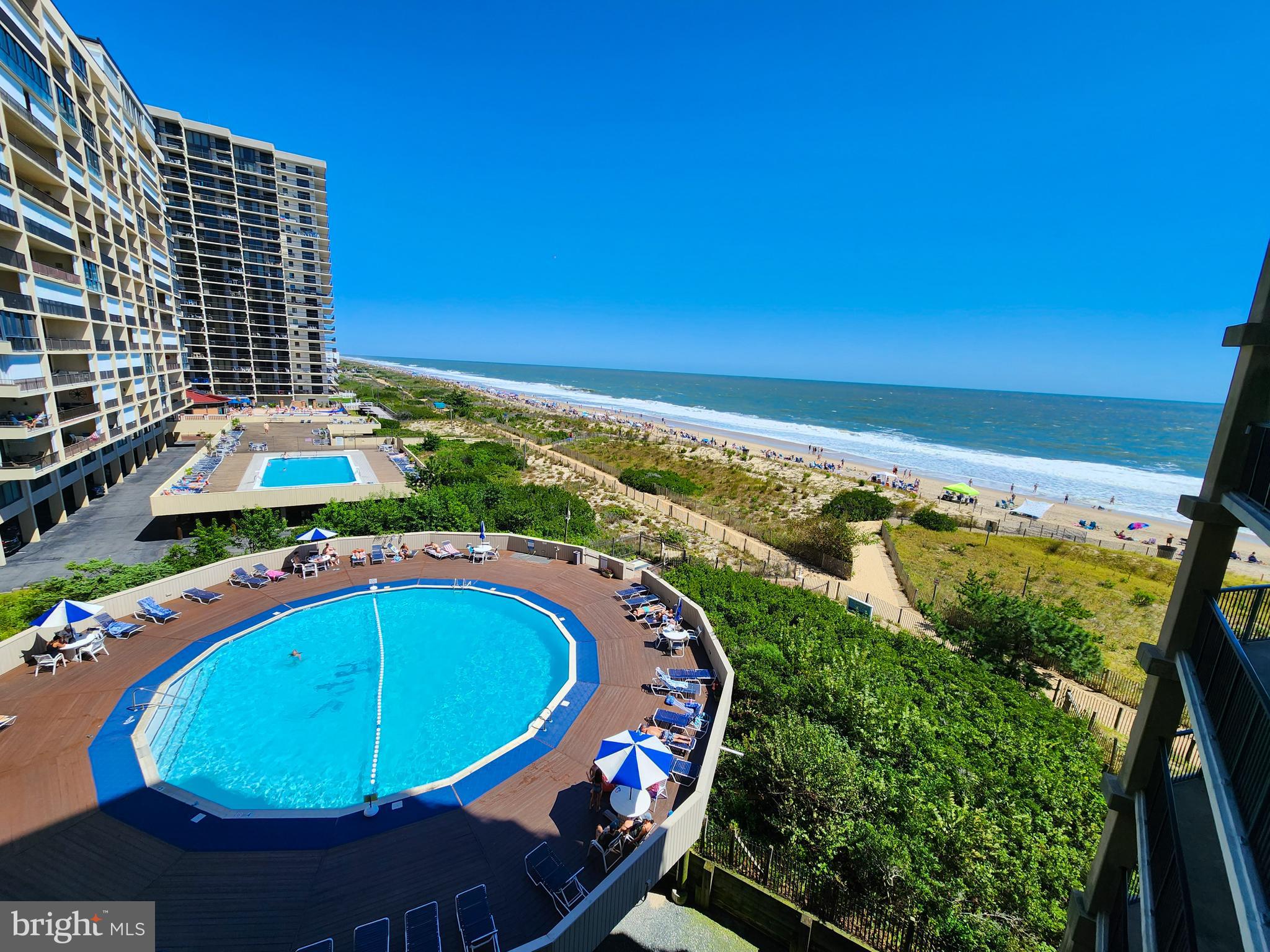 a view of a swimming pool with a yard and outdoor seating