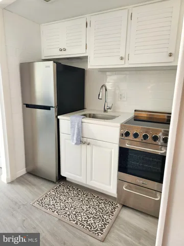 a kitchen with a refrigerator sink and cabinets