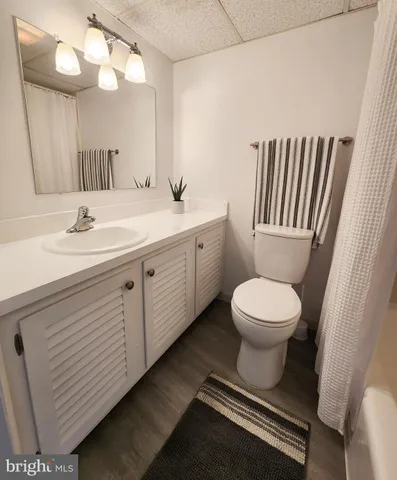 a bathroom with a toilet a sink a mirror and vanity