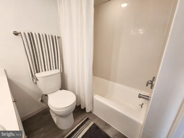 a white toilet sitting next to a bath tub