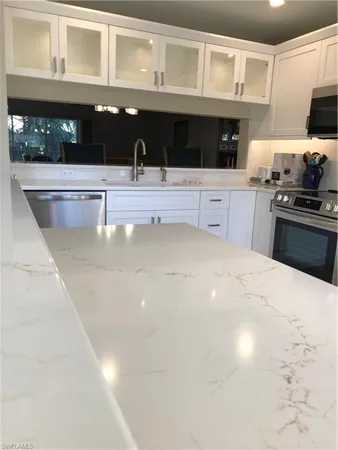 a kitchen with stainless steel appliances a sink a stove and cabinets