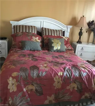 a bedroom with a large bed and a potted plant