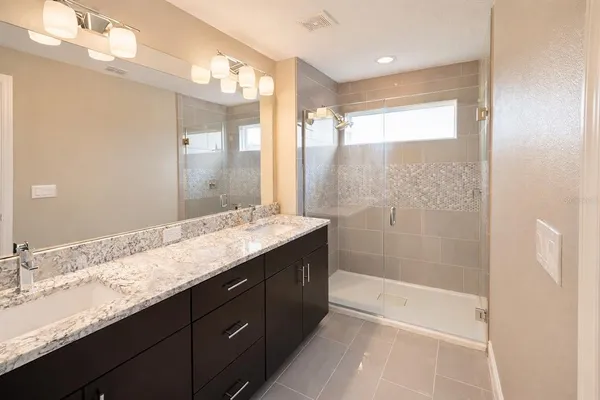 a bathroom with a granite countertop sink mirror and shower